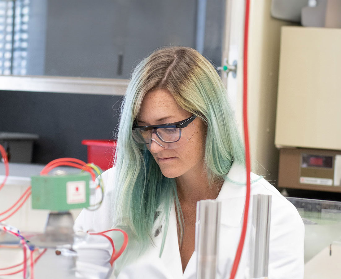 Grad student in a white lab coat performing experiments in the Nuclear Science and Engineering PhD Program.