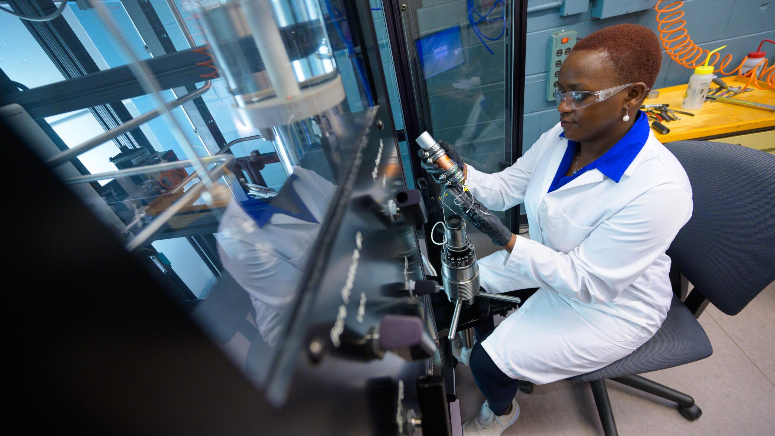 A woman in a lab coat working on a machine.